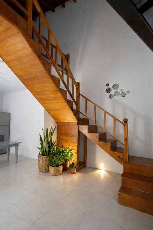 Interior con escalera de madera de María Jimena Suites en Chihuahua